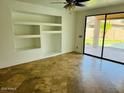 Bright living room with tile flooring, large sliding glass doors, and built in shelves at 3502 W Belle Ave, San Tan Valley, AZ 85144