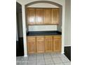 Dining area featuring wood cabinets, a black countertop, and tile flooring at 3633 E Potter Dr, Phoenix, AZ 85050