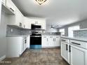 Charming kitchen featuring white cabinets, stainless steel appliances, and tile backsplash at 37061 W Bello Ln, Maricopa, AZ 85138