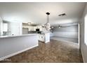 Open concept living room and kitchen with tile flooring and natural light at 37061 W Bello Ln, Maricopa, AZ 85138