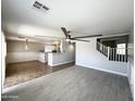Bright living room has a ceiling fan and overlooks the kitchen and staircase at 37061 W Bello Ln, Maricopa, AZ 85138