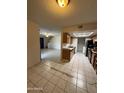 View from a living area looking into the kitchen with dated cabinetry and white appliances at 4231 N 69Th Dr # 1297, Phoenix, AZ 85033