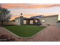 A lush backyard offers a patio, low-maintenance turf, and desert landscaping that is perfect for relaxing at 4231 W Villa Maria Dr, Glendale, AZ 85308