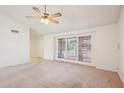 A spacious living room features light carpet, a ceiling fan, and large windows for natural light at 4231 W Villa Maria Dr, Glendale, AZ 85308