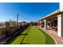 Well-manicured backyard with putting green, flowering plants and covered patio, perfect for entertaining or relaxing at 4304 N Ranier --, Mesa, AZ 85215