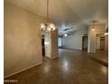 Open-concept living room features tile flooring, vaulted ceilings, and a decorative lighting fixture at 4332 E Frye Rd, Phoenix, AZ 85048