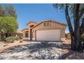 Single-story home showcasing a front-facing two-car garage, neutral-toned exterior, and desert landscaping at 4605 W Beverly Rd, Laveen, AZ 85339