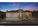 Charming single-story home with a well-maintained yard and a two-car garage at dusk at 4649 E Sourwood Dr, Gilbert, AZ 85298