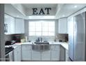Modern kitchen with white cabinets, stainless steel appliances, and a farmhouse sink at 6885 E Cochise Rd # 127, Paradise Valley, AZ 85253