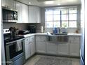 Bright kitchen with white cabinets, stainless steel appliances, and a stainless farmhouse sink at 6885 E Cochise Rd # 127, Paradise Valley, AZ 85253