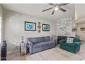 Inviting living room with stacked stone fireplace, blue sofa, a ceiling fan, and decor at 6885 E Cochise Rd # 127, Paradise Valley, AZ 85253