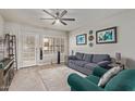 Comfortable living room with a blue sofa, ceiling fan, and bright natural light from the window at 6885 E Cochise Rd # 127, Paradise Valley, AZ 85253