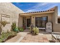 Inviting front entrance featuring custom ironwork, decorative statues, and vibrant potted plants at 7921 E Bonita Dr, Scottsdale, AZ 85250