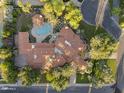 Stunning aerial view of a large property featuring a pool, lush landscaping, and a unique tile roof design at 8815 N 65Th St, Paradise Valley, AZ 85253
