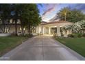 Elegant home exterior with manicured lawn, a grand driveway, and a welcoming portico entrance at 8815 N 65Th St, Paradise Valley, AZ 85253