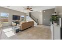 Spacious living room featuring a ceiling fan, tile flooring, and a staircase leading to the upper level at 894 S Buena Vista Dr, Apache Junction, AZ 85120