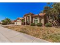 Landscaped front yard and well-maintained home featuring a three-car garage at 9414 S La Rosa Dr, Tempe, AZ 85284