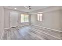 Bright bedroom featuring light gray wood floors, a ceiling fan, and natural light from two windows at 9551 E Redfield Rd # 1061, Scottsdale, AZ 85260