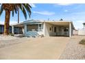 Charming manufactured home featuring a covered carport, mature landscaping, and a cozy, welcoming facade at 103 S 75Th Pl, Mesa, AZ 85208
