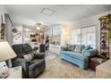 Comfortable living space with a cozy seating area, adjacent dining, and carpet flooring at 103 S 75Th Pl, Mesa, AZ 85208