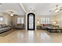 Bright living room featuring tile floors, ceiling fans, and an ornate wrought iron front door at 10747 W Via Del Sol --, Peoria, AZ 85373
