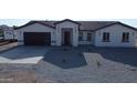 New construction with neutral colored stucco, gray roof, modern garage door, and low maintenance rock yard at 11798 S 216Th Ave, Buckeye, AZ 85326