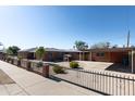Expansive backyard featuring a brick home, carport, playhouse and secure wrought iron gate at 1330 E Monte Vista Rd, Phoenix, AZ 85006