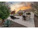 A serene backyard showcases a cozy fire pit area, outdoor kitchen, and relaxing patio furniture at 13583 S 177Th Ln, Goodyear, AZ 85338