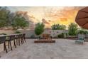 Spacious backyard with a built-in bar, comfortable seating around a fire pit, and desert landscaping at 13583 S 177Th Ln, Goodyear, AZ 85338