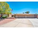 Inviting exterior showcasing a wide driveway leading to a two-car garage, complemented by a tidy front yard at 16425 N 46Th Dr, Glendale, AZ 85306