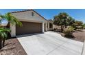 A concrete driveway leads to a well-maintained home with desert landscaping and a spacious three-car garage at 16747 W Berkeley Rd, Goodyear, AZ 85395