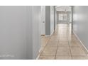 Hallway featuring tile flooring, neutral paint, and an arched entryway in an open floor plan at 16763 W Magnolia St, Goodyear, AZ 85338