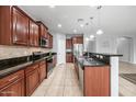 Updated kitchen with tile flooring, granite countertops, and stainless steel appliances at 16763 W Magnolia St, Goodyear, AZ 85338