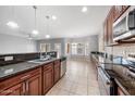 Kitchen with stainless steel appliances, granite countertops, and dark wood cabinetry at 16763 W Magnolia St, Goodyear, AZ 85338