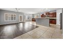 Open floor plan featuring tile flooring, hardwood, and an adjoining dining area at 16763 W Magnolia St, Goodyear, AZ 85338