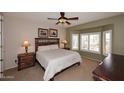 Cozy bedroom with a large window, carpet, and a ceiling fan at 17630 N Somerset Dr, Surprise, AZ 85374