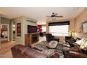 Warm living room featuring tile flooring, a ceiling fan, and a fireplace at 17630 N Somerset Dr, Surprise, AZ 85374