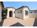 Charming home exterior featuring a private courtyard with tiled flooring and stucco walls at 17900 W Briarwood Dr, Goodyear, AZ 85338