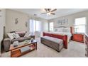 Comfortable main bedroom with ceiling fan, sitting area, and abundant natural light from the surrounding windows at 18047 W Caribbean Ln, Surprise, AZ 85388