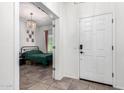 View from hallway to a bedroom with a bed with a dark green comforter and a decorative chandelier at 1806 W Fetlock Trl, Phoenix, AZ 85085