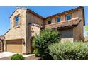 Charming two-story home with a well-manicured lawn, a brown door, and a two-car garage at 1806 W Fetlock Trl, Phoenix, AZ 85085