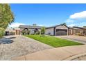 Beautiful single-Gathering home with green lawn, striking dark garage door, and decorative shrubbery at 1914 W Onza Ave, Mesa, AZ 85202