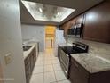 Modern kitchen with stainless steel appliances, granite countertops, and dark wood cabinets at 2019 W Lemon Tree Pl # 1124, Chandler, AZ 85224