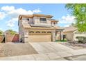 Two-story home featuring a tile roof, neutral stucco exterior, a two-car garage and brick paved driveway at 21054 N Sansom Dr, Maricopa, AZ 85138