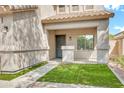 Covered front porch with a small grassy area and decorative railing. A dark metal door provides entrance to the home at 21054 N Sansom Dr, Maricopa, AZ 85138