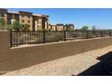 Apartment complex featuring a retaining wall in the backyard and a wrought iron fence for added security at 21244 N 58Th St, Phoenix, AZ 85054