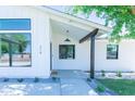 Inviting front porch with contemporary design elements, including a stylish black door frame and sleek lighting at 214 W Ruth Ave, Phoenix, AZ 85021