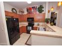Well-lit kitchen with light countertops, wood cabinets, and black appliances at 2150 W Alameda Rd # 2037, Phoenix, AZ 85085