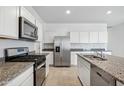 Modern kitchen showcasing stainless steel appliances, granite countertops, and white cabinetry at 22530 N Lynn St, Maricopa, AZ 85138