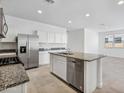 Stylish kitchen featuring stainless steel appliances, island with sink, and sleek countertops at 22530 N Lynn St, Maricopa, AZ 85138